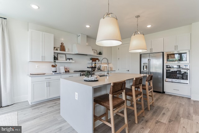 kitchen featuring open shelves, exhaust hood, light wood finished floors, and stainless steel appliances