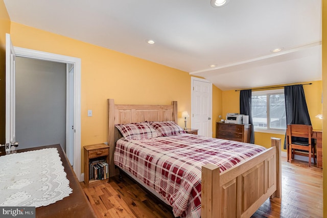 bedroom with lofted ceiling, recessed lighting, and wood finished floors