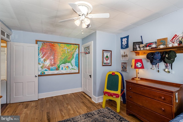 bedroom featuring ceiling fan, baseboards, and wood finished floors