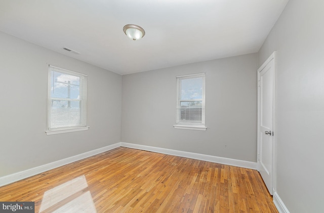 unfurnished room featuring visible vents, baseboards, and light wood finished floors