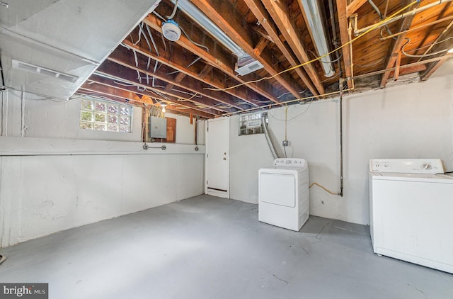 basement with electric panel, separate washer and dryer, and visible vents