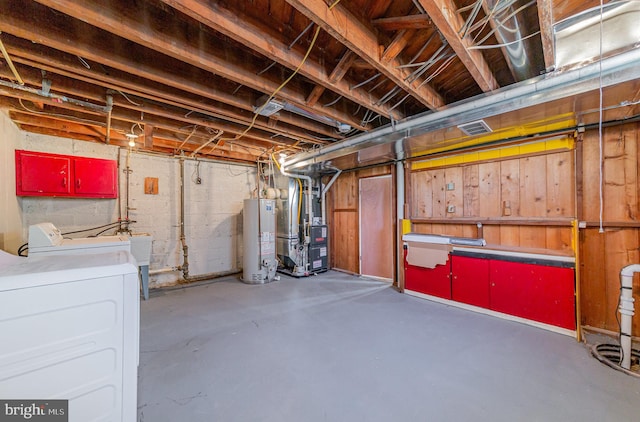 unfinished basement featuring washer and dryer, visible vents, heating unit, and water heater