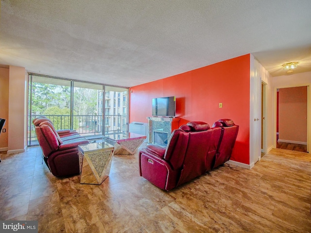 living area with a wall of windows, a fireplace, baseboards, and a textured ceiling