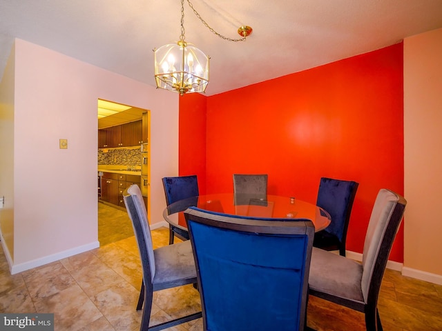 dining area featuring baseboards and a chandelier