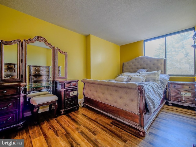 bedroom with wood finished floors and a textured ceiling