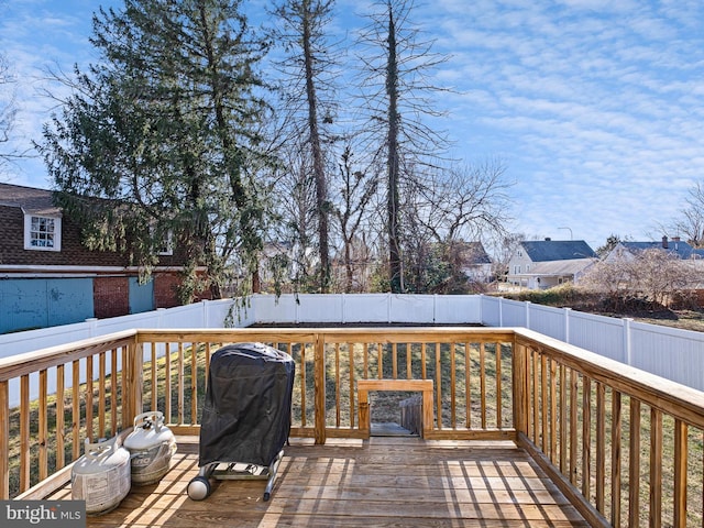 wooden deck with a fenced backyard and grilling area