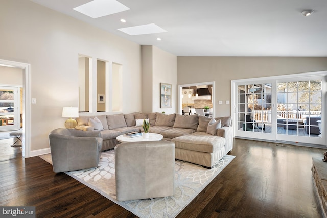 living room with high vaulted ceiling, wood finished floors, recessed lighting, a skylight, and baseboards