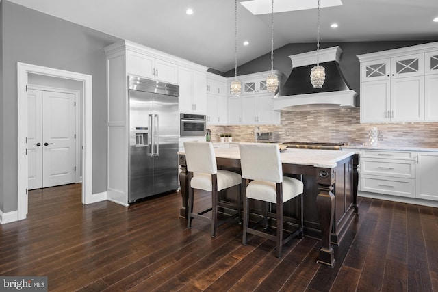 kitchen featuring premium range hood, lofted ceiling, stainless steel appliances, light countertops, and white cabinets