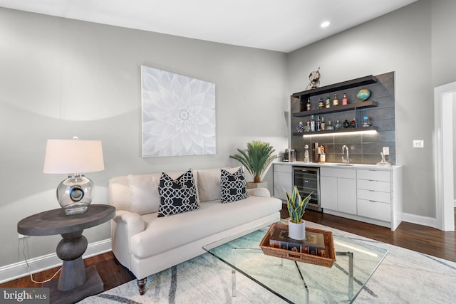 living area with baseboards, beverage cooler, dark wood finished floors, recessed lighting, and wet bar