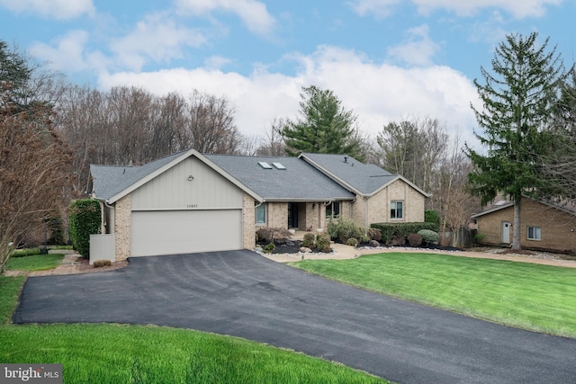 single story home with aphalt driveway, a front yard, a shingled roof, a garage, and brick siding