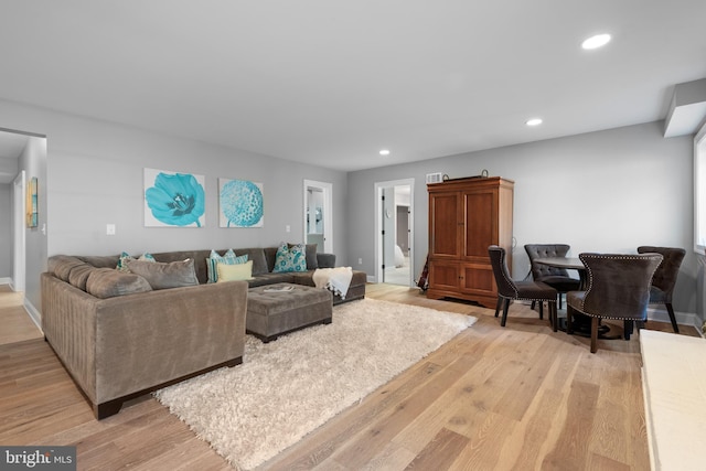 living room with recessed lighting, baseboards, and light wood-style floors