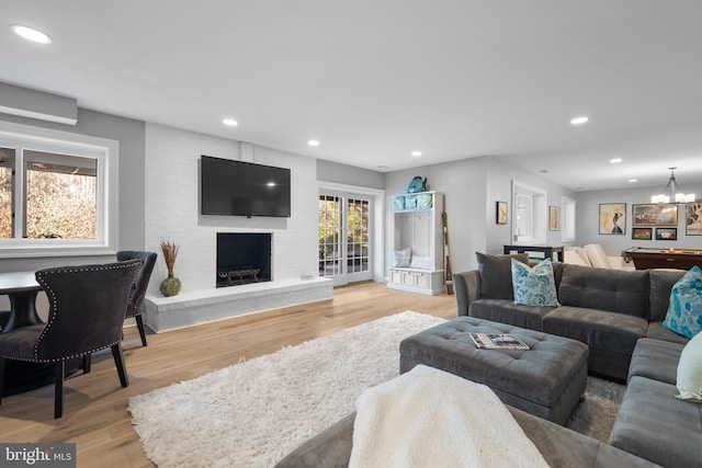 living room with a fireplace, recessed lighting, and light wood-style floors