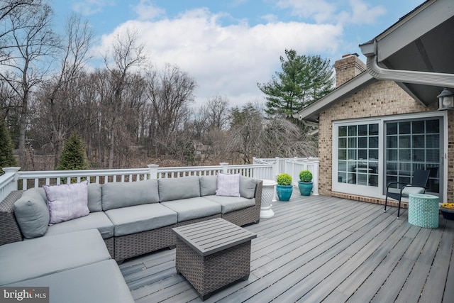 wooden terrace with an outdoor living space