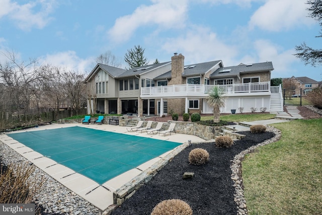 view of pool with a covered pool, stairs, a yard, a deck, and a patio