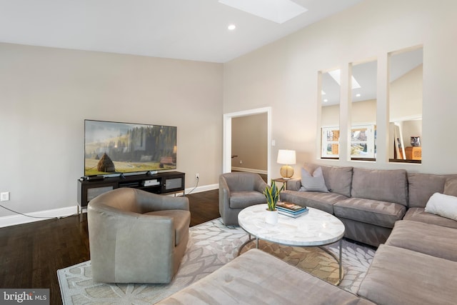 living room featuring recessed lighting, baseboards, wood finished floors, and a skylight