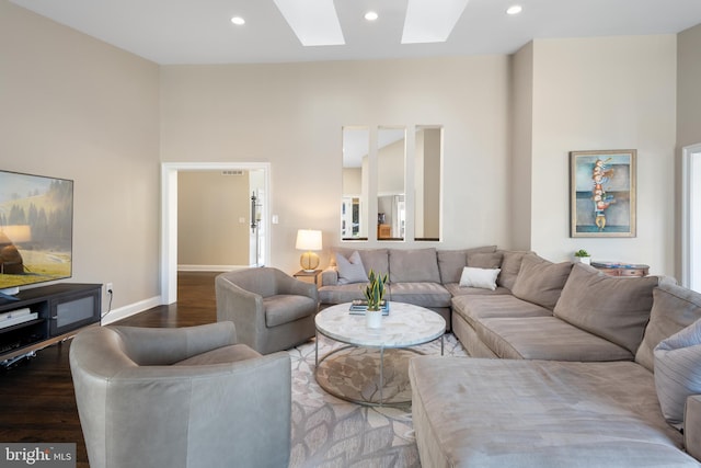 living room featuring recessed lighting, a skylight, baseboards, and wood finished floors