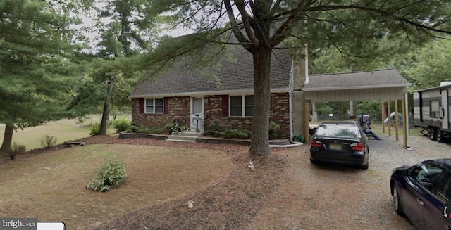 view of front of property featuring brick siding, driveway, a shingled roof, and a carport