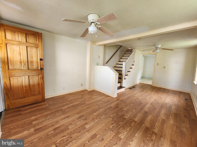 interior space with visible vents, a textured ceiling, wood finished floors, stairway, and baseboards