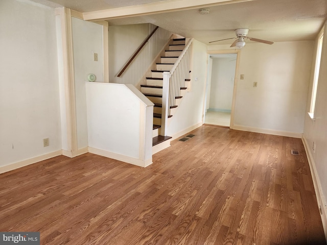 interior space featuring visible vents, baseboards, wood finished floors, and stairs