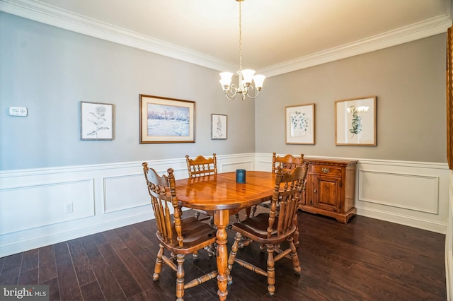 dining area featuring wainscoting, dark wood-type flooring, an inviting chandelier, and ornamental molding