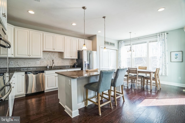 kitchen with a sink, a center island, dark wood-style flooring, and stainless steel appliances