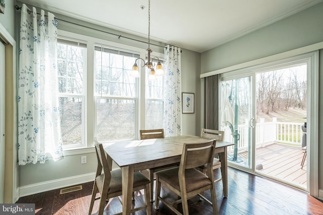 dining area featuring an inviting chandelier, baseboards, visible vents, and dark wood-style flooring