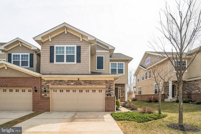 view of front of home featuring driveway, stone siding, a front yard, a garage, and brick siding