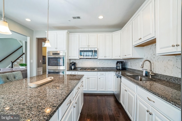 kitchen with visible vents, dark wood finished floors, a sink, white cabinets, and appliances with stainless steel finishes