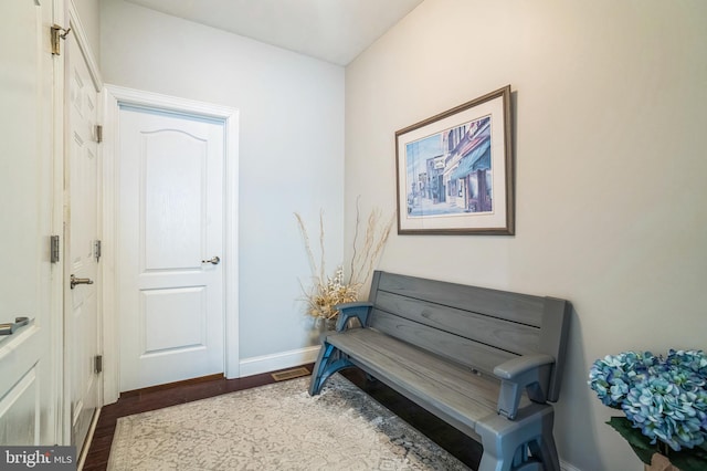 living area featuring dark wood-type flooring and baseboards