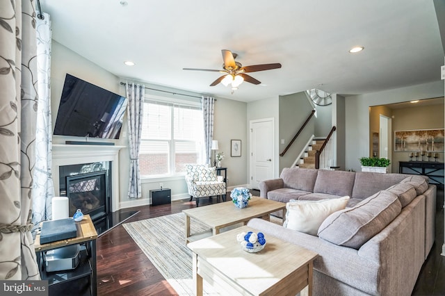 living room featuring a high end fireplace, baseboards, stairway, recessed lighting, and wood finished floors