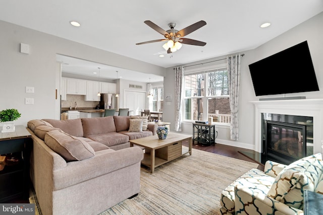 living area featuring recessed lighting, baseboards, wood finished floors, and a ceiling fan