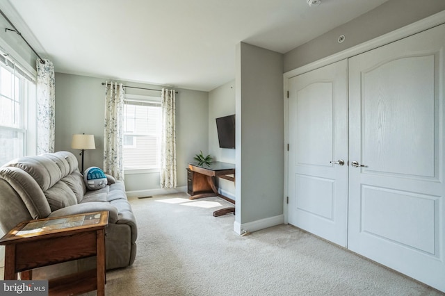 carpeted living area with visible vents and baseboards