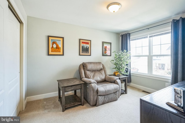 sitting room with baseboards, light carpet, and visible vents