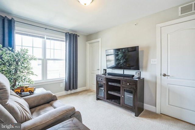 living room featuring visible vents, light carpet, and baseboards