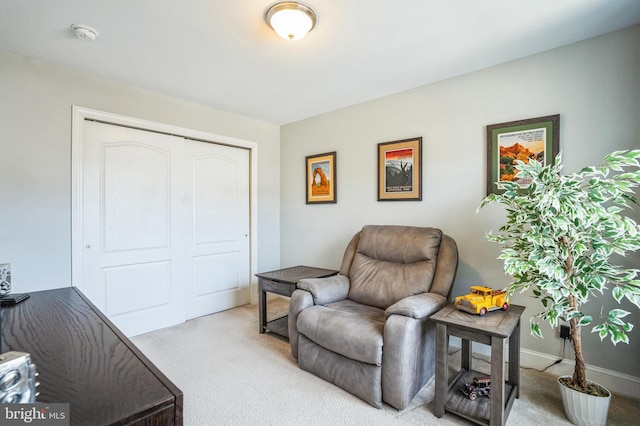 sitting room featuring baseboards and light carpet