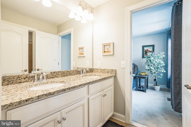 full bath featuring double vanity, baseboards, and a sink