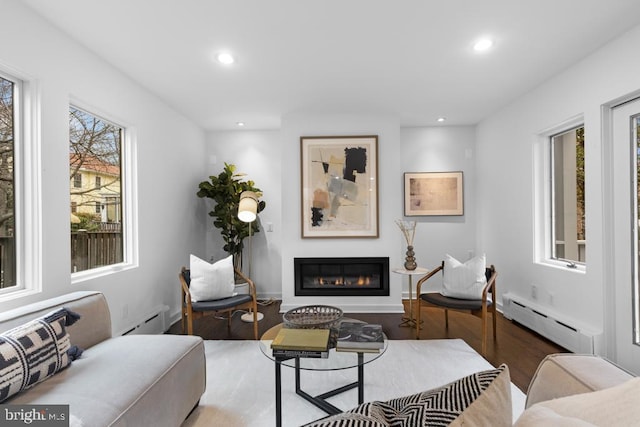 living room featuring a baseboard heating unit, recessed lighting, wood finished floors, a glass covered fireplace, and a baseboard radiator