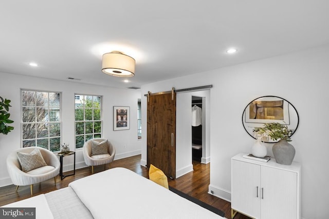 bedroom with recessed lighting, a barn door, visible vents, and dark wood finished floors