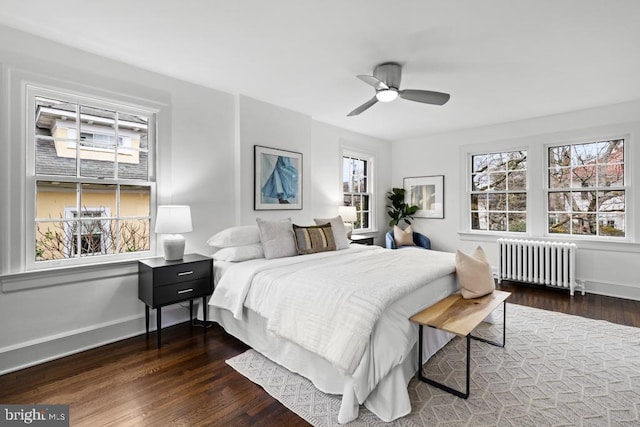 bedroom featuring radiator, wood finished floors, baseboards, and ceiling fan