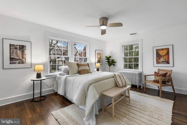 bedroom with hardwood / wood-style flooring, radiator, baseboards, and visible vents