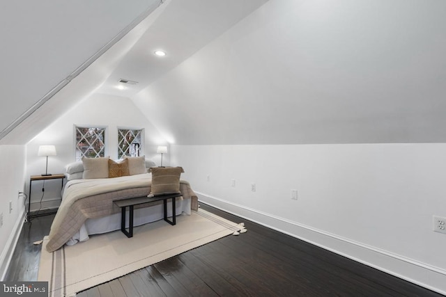 bedroom with dark wood-type flooring, baseboards, and vaulted ceiling