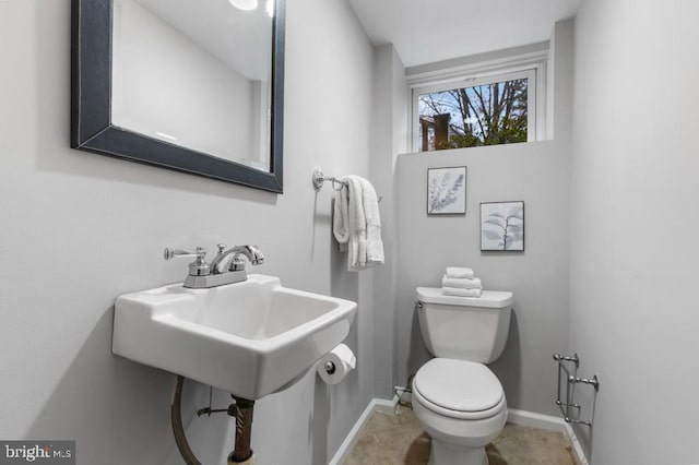 half bathroom with toilet and baseboards