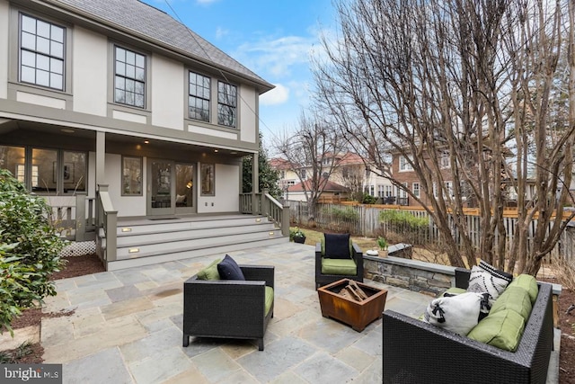 view of patio featuring an outdoor living space with a fire pit and fence