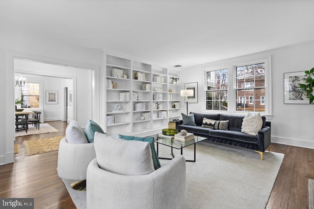 living area featuring baseboards, plenty of natural light, and hardwood / wood-style floors