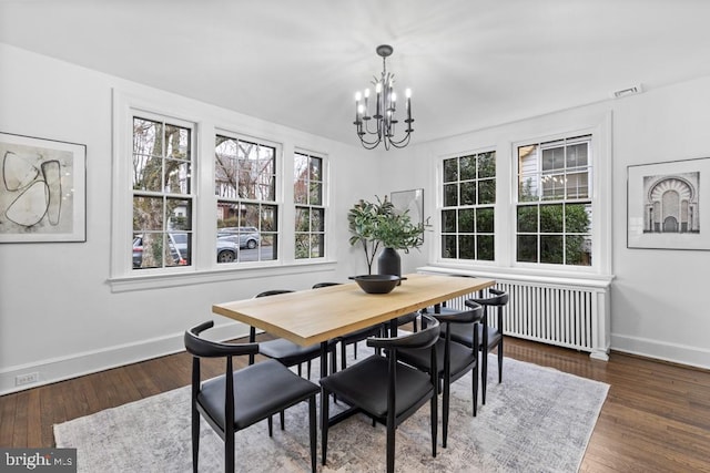 dining space featuring a notable chandelier, hardwood / wood-style flooring, radiator, and a healthy amount of sunlight