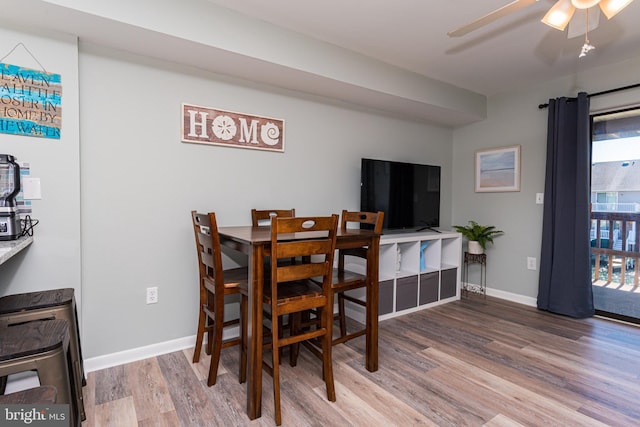 dining space featuring ceiling fan, baseboards, and wood finished floors