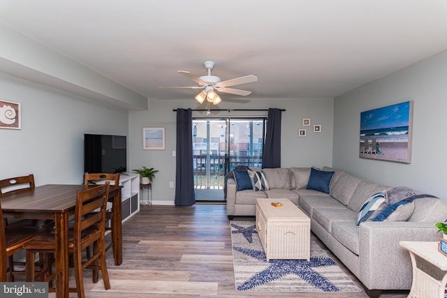 living room with wood finished floors, baseboards, and ceiling fan