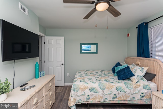 bedroom with ceiling fan, visible vents, baseboards, and dark wood finished floors