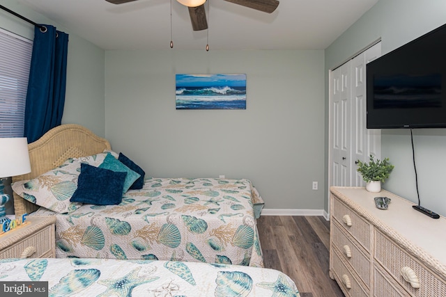 bedroom with a closet, dark wood-style floors, a ceiling fan, and baseboards