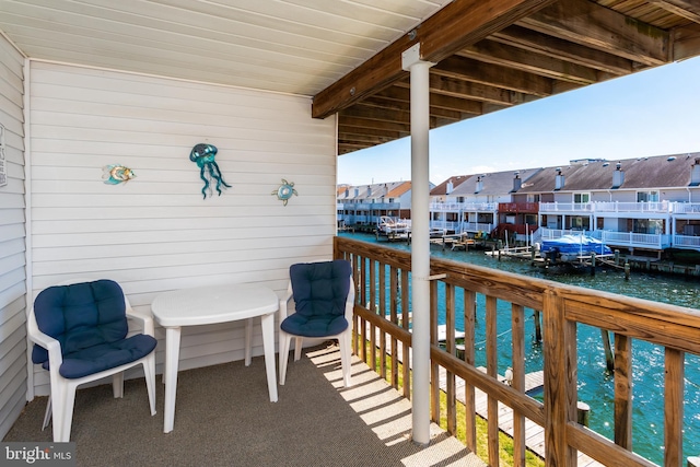 balcony with a residential view and a water view